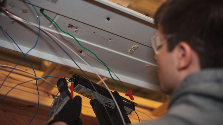 Electrician repairing ballast on florescent light