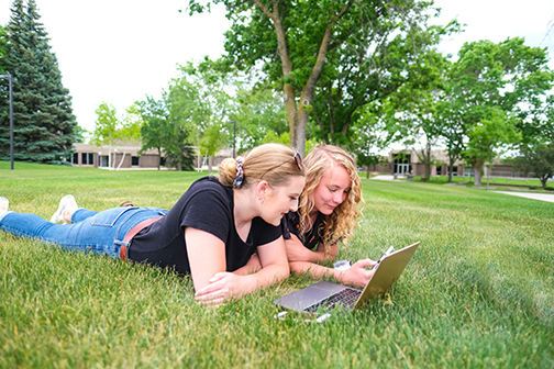 Students at laptop outdoors