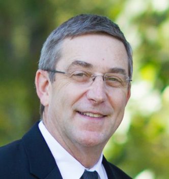 Headshot for Tom Bipes in a suit and glasses Headshot for Tom Bipes in a suit and glasses