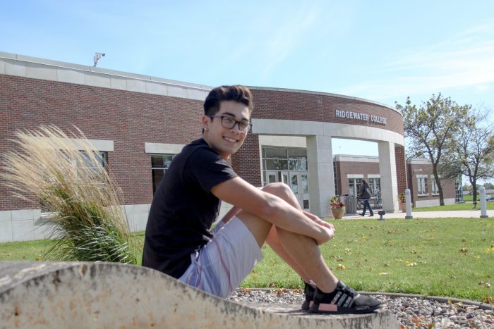 Photo of a student sitting on a rock.