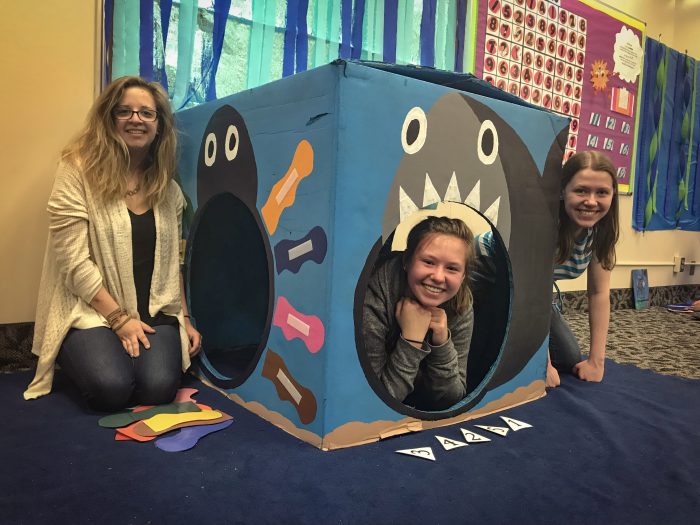 Photo of a group of teachers looking out from a piece of playground equipment.