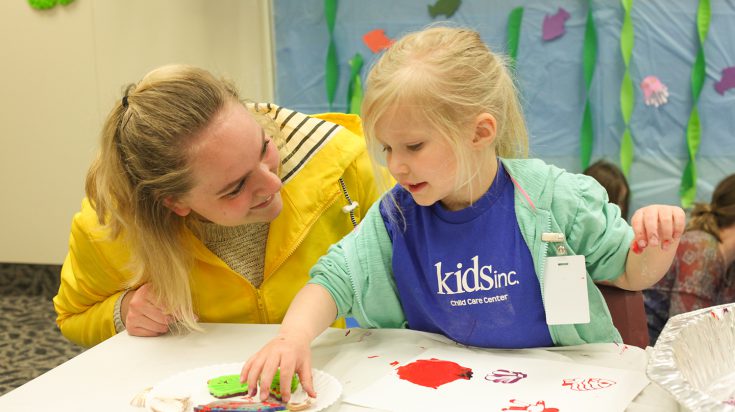 Photo of a young girl playing with a teacher